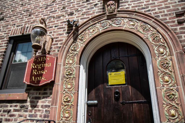 A sign posted on the door of the Regina Rose Apartments in Elkins Park, Pa., warns of structural danger. (Kimberly Paynter/WHYY)