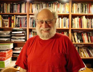 Larry Robin stands in front of a wall full of books