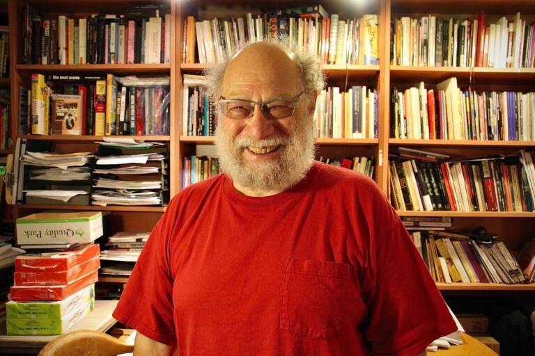 Larry Robin stands in front of a wall full of books