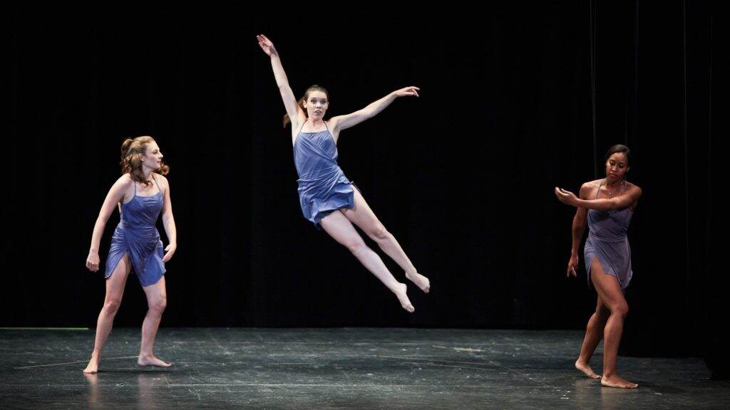 Dancers dance onstage.