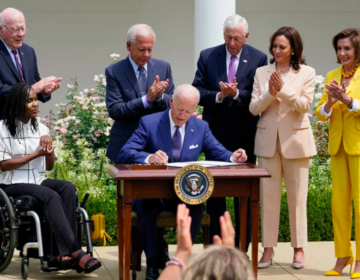 President Joe Biden, center, signs a proclamation during an event in the Rose Garden of the White House in Washington, Monday, July 26, 2021, to highlight the bipartisan roots of the Americans with Disabilities Act. (Susan Walsh/AP)