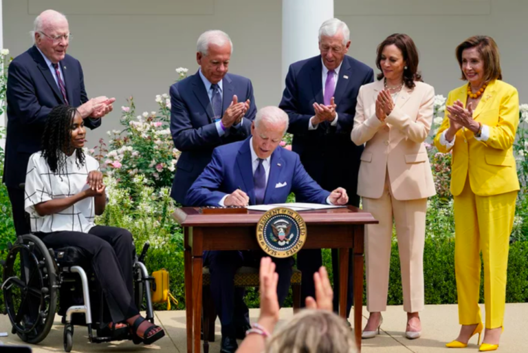 President Joe Biden, center, signs a proclamation during an event in the Rose Garden of the White House in Washington, Monday, July 26, 2021, to highlight the bipartisan roots of the Americans with Disabilities Act. (Susan Walsh/AP)