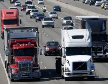 Trucks and cars travel down the highway.