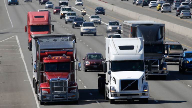 Trucks and cars travel down the highway.