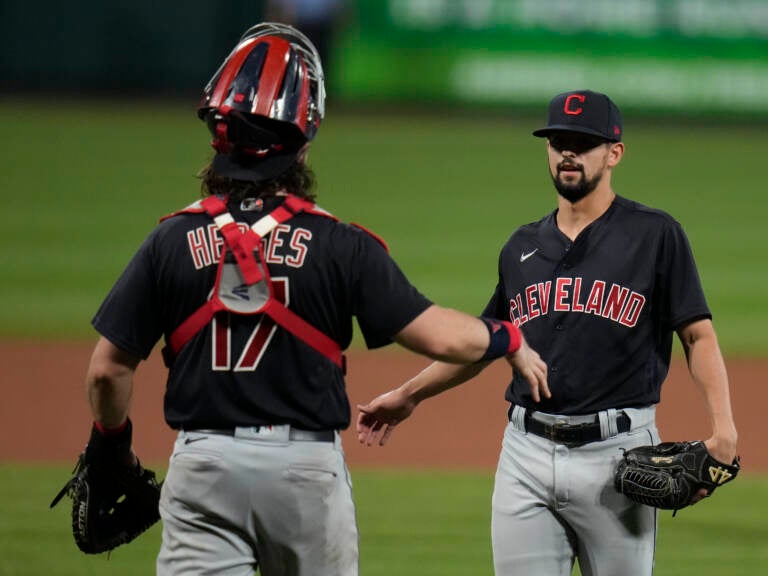 Cleveland relief pitcher Nick Sandlin (right) and catcher Austin Hedges celebrate a 10-1 victory over the St. Louis Cardinals on June 8, 2021, in St. Louis. On Friday, the Cleveland team announced its new name, the Guardians. (Jeff Roberson/AP)