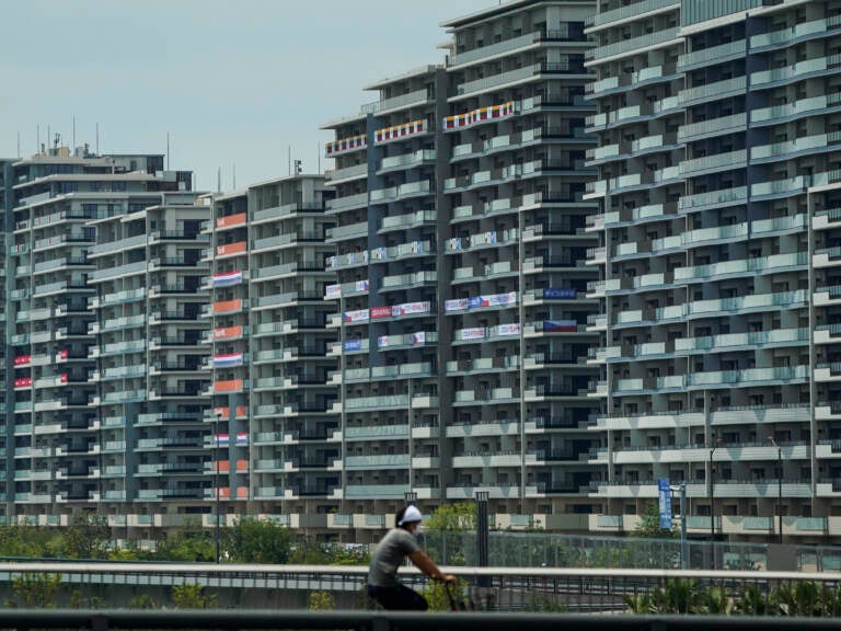 A man rides a bike near the village for the Summer Olympics in Tokyo. On Saturday, officials announced the first case of COVID-19 found at the center housing thousands of athletes. (Jae C. Hong/AP)