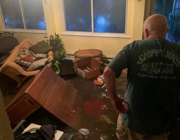 A Bucks County resident observes the aftermath of flooding at his residence.