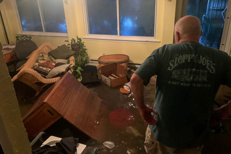 A Bucks County resident observes the aftermath of flooding at his residence.