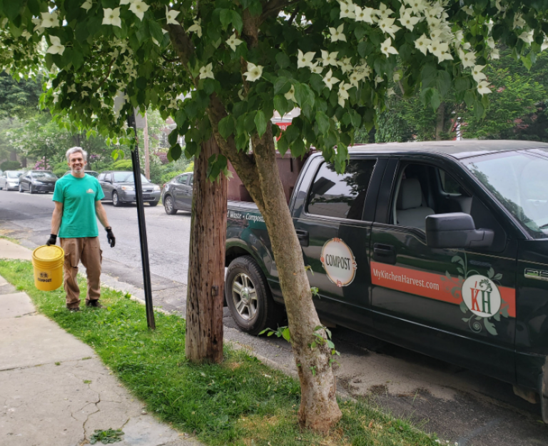 Chris Pieretti holds up a compost bucket on the sidewalk