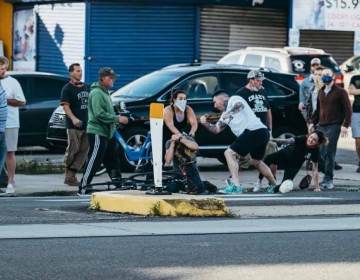 A group of people attack a man who has been knocked off his bike