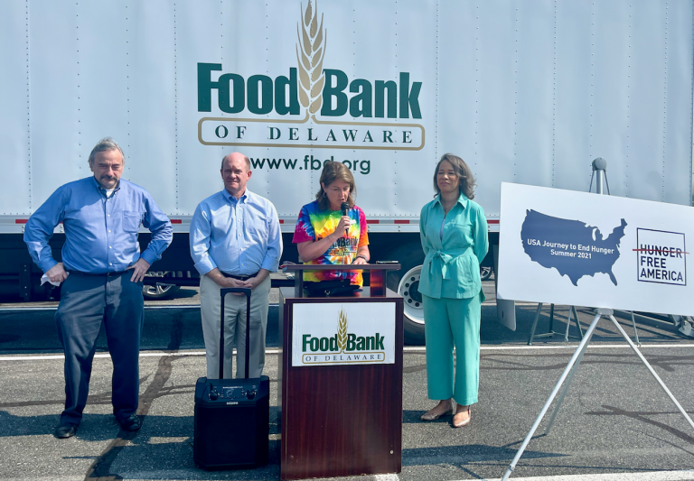 Hunger Free America CEO Joel Berg (left) joins U.S. Sen. Chris Coons, Food Bank of Delaware president Cathy Kanefsky and Delaware Congresswoman Lisa Blunt Rochester at a food distribution event in Georgetown Tuesday morning. (Johnny Perez-Gonzalez / WHYY)