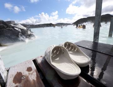 A pair of sandals are pictured in the foreground, with Blue Lagoon in the background