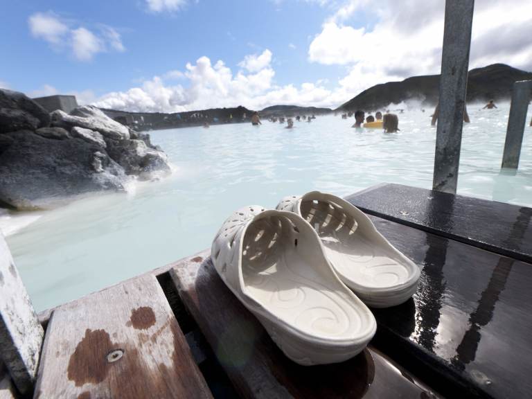 A pair of sandals are pictured in the foreground, with Blue Lagoon in the background