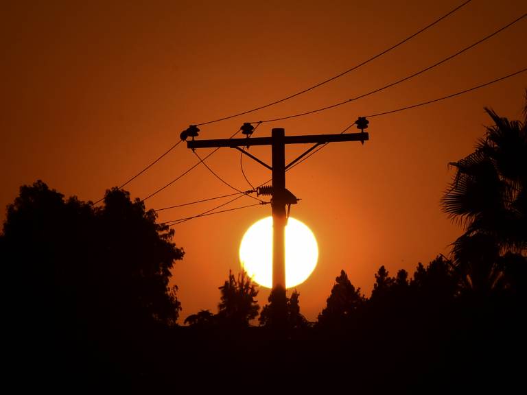 The sun sets behind power lines in Los Angeles in September.
(Frederic J. Brown/AFP via Getty Images)