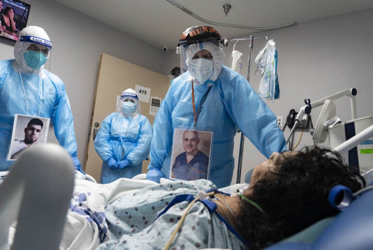 Medical staff members check on a patient in the COVID-19 Intensive Care Unit