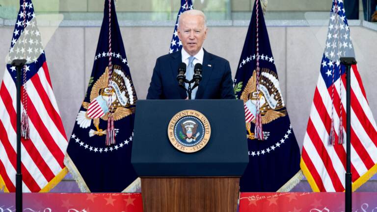 Biden speaks from a podium with American flags behind him at the National Constitution Center