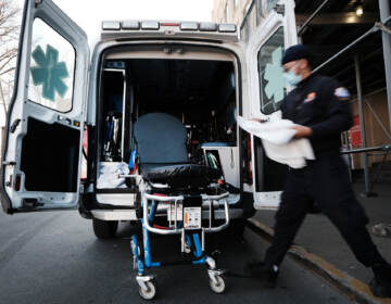 In June, New York City started its Behavioral Health Emergency Assistance Response Division, or B-HEARD, to provide more targeted care for those struggling with mental health issues and emergencies. In this photo from March, an EMT worker cleans a gurney after transporting a suspected COVID patient in New York City. (Spencer Platt/Getty Images)