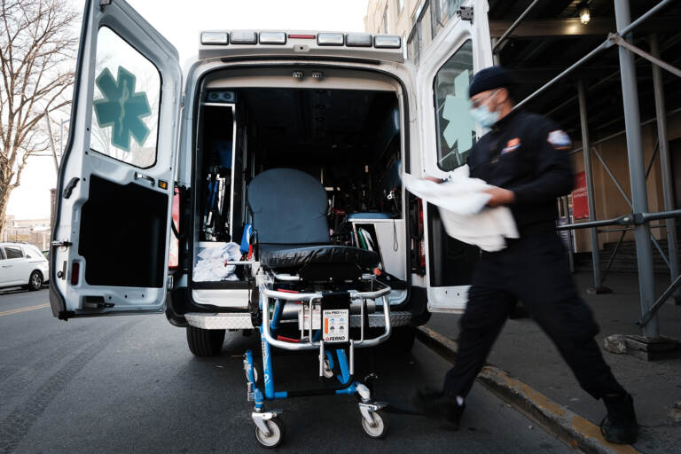 In June, New York City started its Behavioral Health Emergency Assistance Response Division, or B-HEARD, to provide more targeted care for those struggling with mental health issues and emergencies. In this photo from March, an EMT worker cleans a gurney after transporting a suspected COVID patient in New York City. (Spencer Platt/Getty Images)