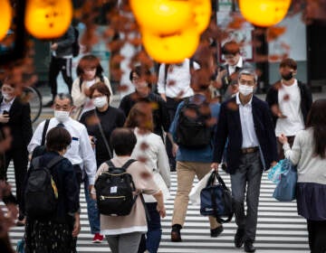 People in Tokyo wear masks on May 7. Daily coronavirus infections in Japan's capital have topped 4,000 — nearly four times as many as a week ago. (Yuichi Yamazaki/Getty Images)