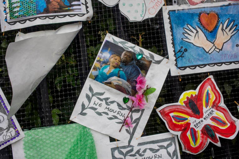 A fence alongside Greenwood Cemetery is covered with COVID-19 memorial art