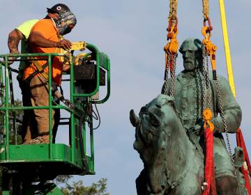 Workers remove a statue of Confederate Gen. Robert E. Lee from Market Street Park on Saturday in Charlottesville, Va. (Win McNamee/Getty Images)