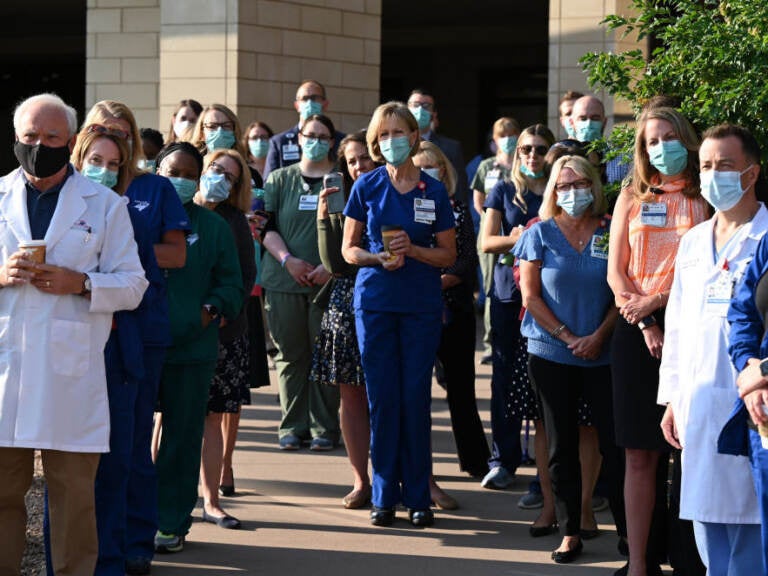 Front-line workers at a medical center in Aurora, Colo., gather for a COVID-19 memorial on July 15 to commemorate the lives lost in the coronavirus pandemic. New estimates say many thousands more will die in the U.S. this summer and fall. (Hyoung Chang/MediaNews Group/Denver Post via Getty Images)