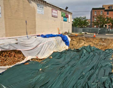 Residents are speculating that a torn up parking lot at 5th and Spring Garden Streets in Philadelphia is a grave sit in the midst of excavation. (Kimberly Paynter/WHYY)