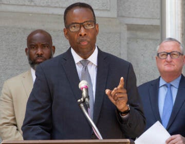 Darrell Clarke gestures while speaking from a podium, with other elected officials behind him