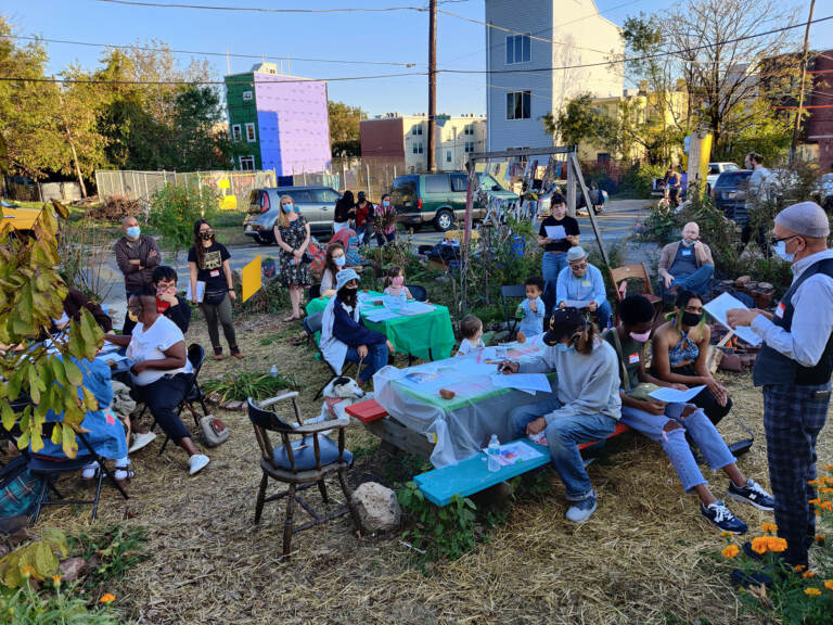 Residents attend an outdoor event with picnic tables