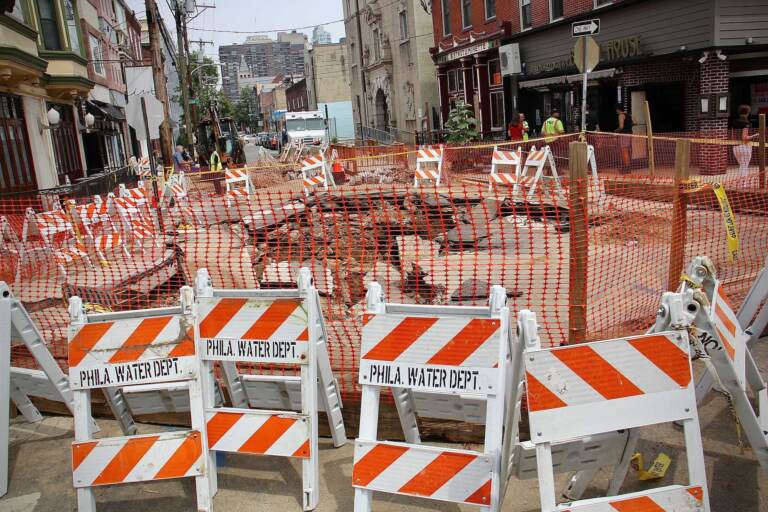 A gaping hole at 6th and Bainbridge streets is closed off by Philly Streets Department barriers