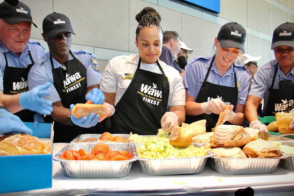 Philadelphia Police Commissioner Danielle Outlaw (center) and members of the police department compete against the fire department in a hoagie-making race