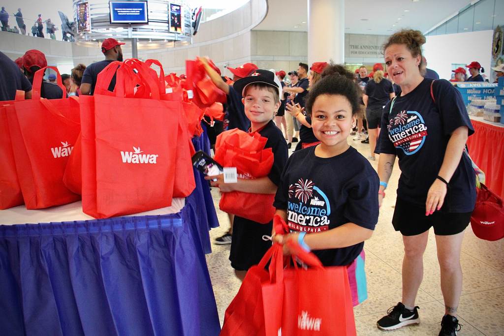 Alex Avallon and Sereniti Fripps help out with Wawa Hoagie Day at the National Constitution Center with their moms