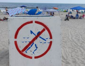 An overturned lifeguard stand warns swimmers that the Park Place beach in Ocean City, New Jersey is unguarded because of a staffing shortage. (Tom MacDonald/WHYY)