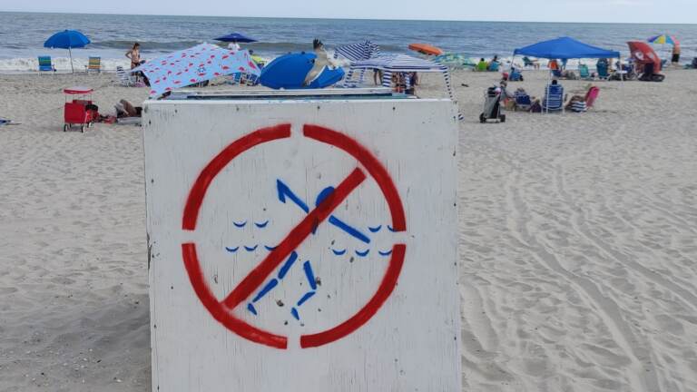 An overturned lifeguard stand warns swimmers that the Park Place beach in Ocean City, New Jersey is unguarded because of a staffing shortage. (Tom MacDonald/WHYY)