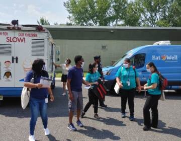 Vaccine team goes out to knock on doors as an ice cream truck waits to offer sweet treats in Camden (Tom MacDonald/WHYY)