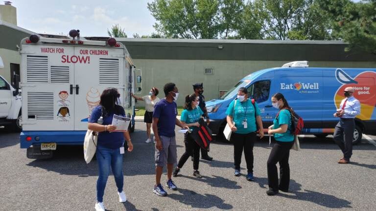 Vaccine team goes out to knock on doors as an ice cream truck waits to offer sweet treats in Camden (Tom MacDonald/WHYY)