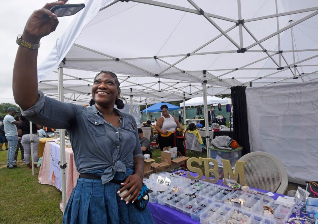 Vendor takes selfie at Mask Melanin Market.