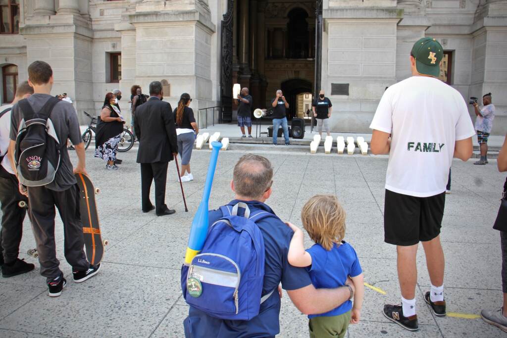 A crowd gathers outside City Hall where a small group of activists use small coffins to call attention to the toll of gun violence in Philadelphia