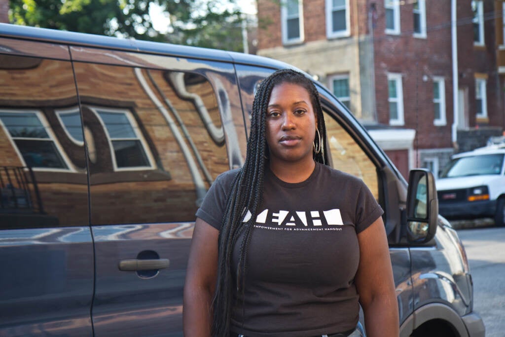 Kendra Van de Water stands in front of a van