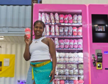 Emani Outterbridge holds up yarn in front of one of her vending machines