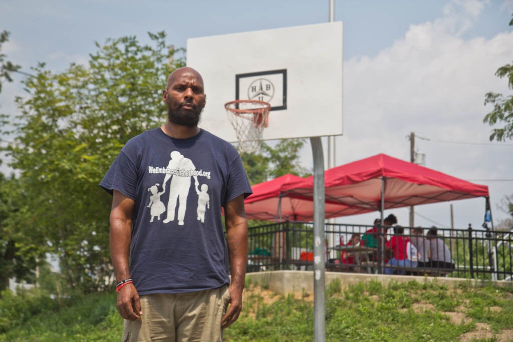 Derrick Pratt stands in front of a basketball hoop