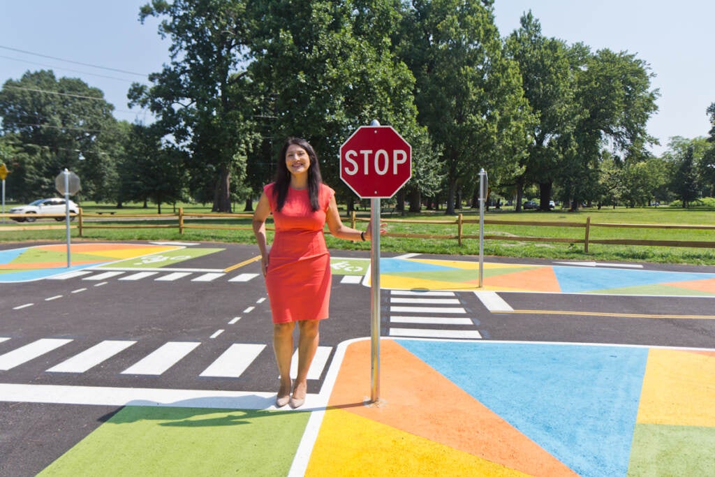 Stephanie Rivera Fenniri stands next to a stop sign at Lil’ Philly Safety Village