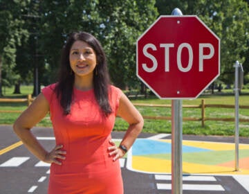 Stephanie Rivera Fenniri stands next to a stop sign at Lil’ Philly Safety Village