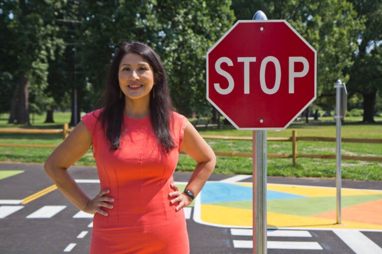 Stephanie Rivera Fenniri stands next to a stop sign at Lil’ Philly Safety Village