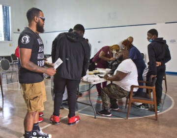 Anton Moore (seated), executive director of Unity in the Community, at the orientation for a carpentry training program on August 5, 2021. Moore raised funds for the 20-week program that pays young men a stipend, offers mental health services and provides mentorship opportunities. (Kimberly Paynter/WHYY)