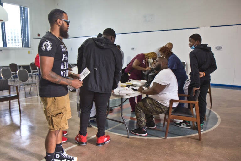 Anton Moore (seated), executive director of Unity in the Community, at the orientation for a carpentry training program on August 5, 2021. Moore raised funds for the 20-week program that pays young men a stipend, offers mental health services and provides mentorship opportunities. (Kimberly Paynter/WHYY)