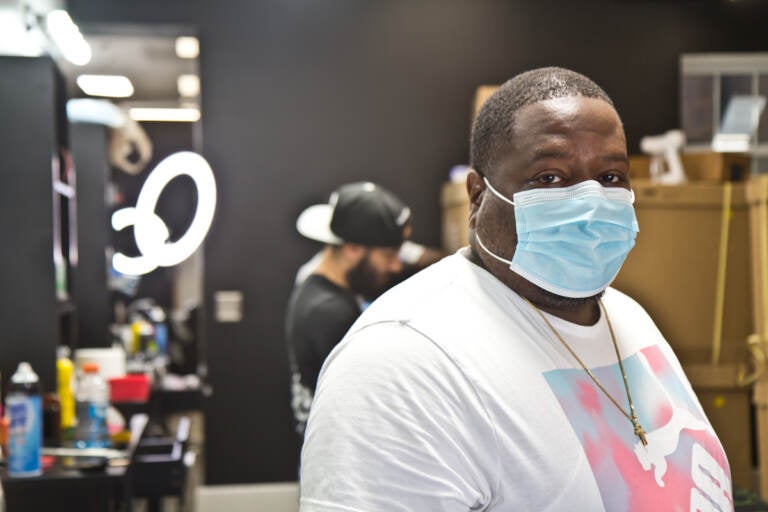 Javan Rankines wears a face mask inside a barber shop