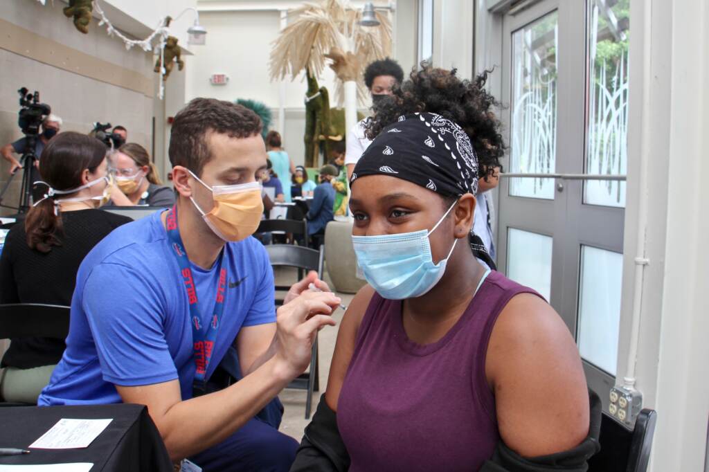 Zaliyah Dozier, an 11th grader at Lankenau high School gets her first shot of the COVID-19 vaccine during a clinic at the Philadelphia Zoo