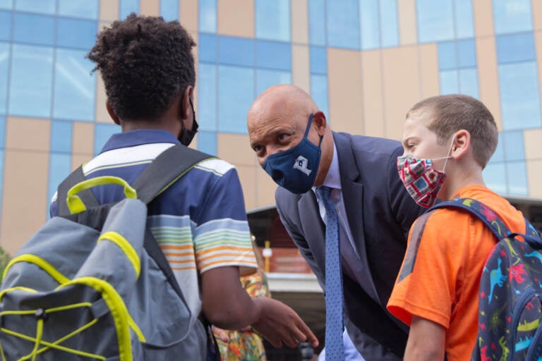 Superintendent William Hite greets students while wearing a face mask