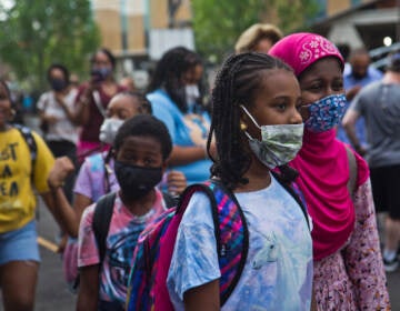 Students wear face masks outside of their school in Philly